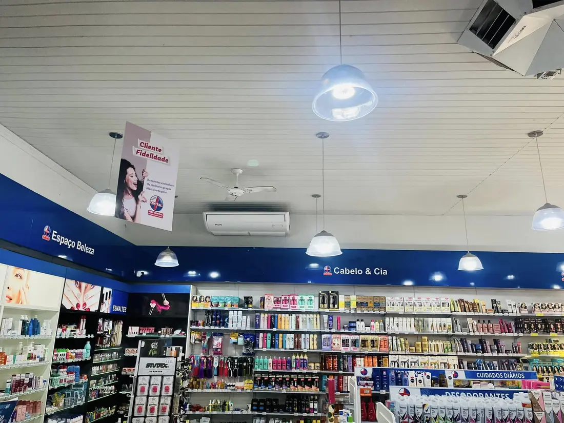 Unidade split fixada no teto de uma loja com prateleiras e iluminação comercial